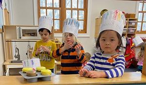 孩子们戴着厨师帽在面包店玩